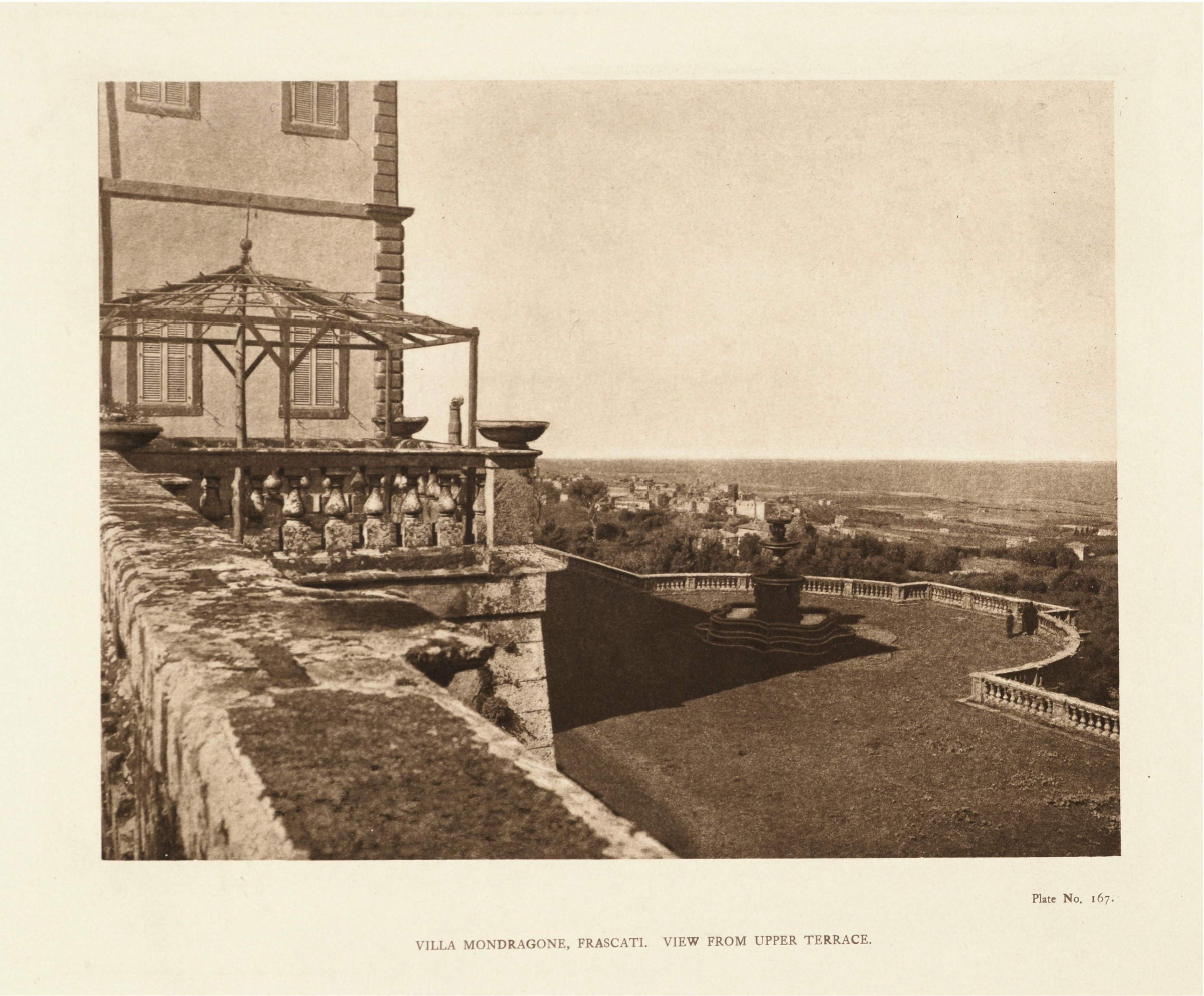 Sepia photo of Villa Mondragone; the foreground shows a stone terrace and a gazebo while a lower terrace with a round fountain, balustrades and two walking figures overlooks landscape vista.