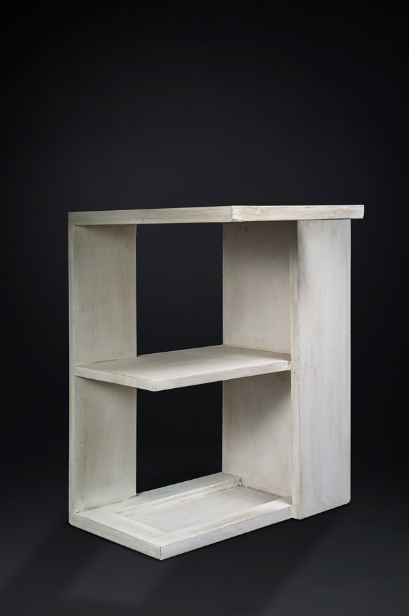 Small white wooden cabinet with three open shelves against a black background.