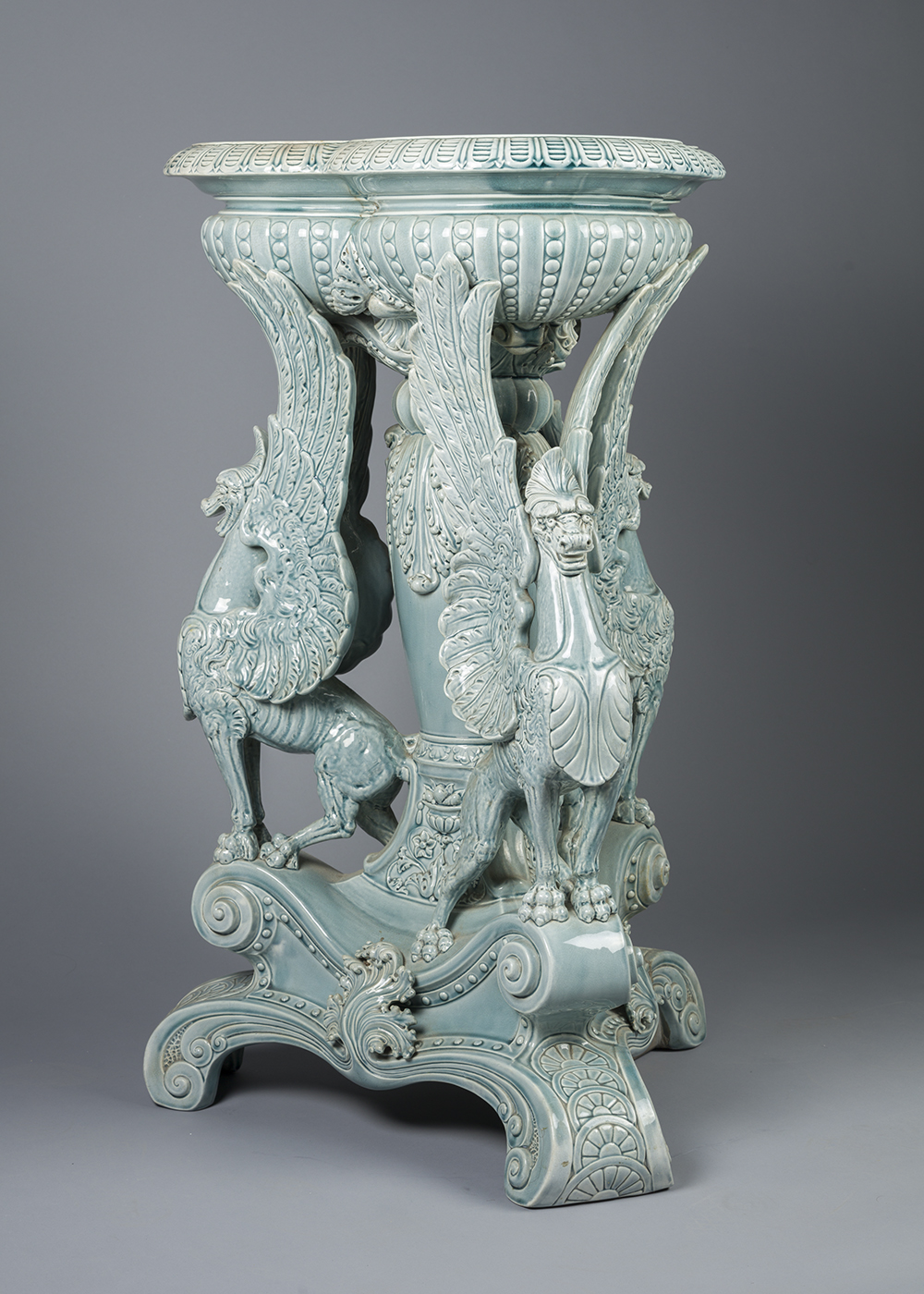 Jade colored majolica fern stand with three griffin supports and pedestal base.