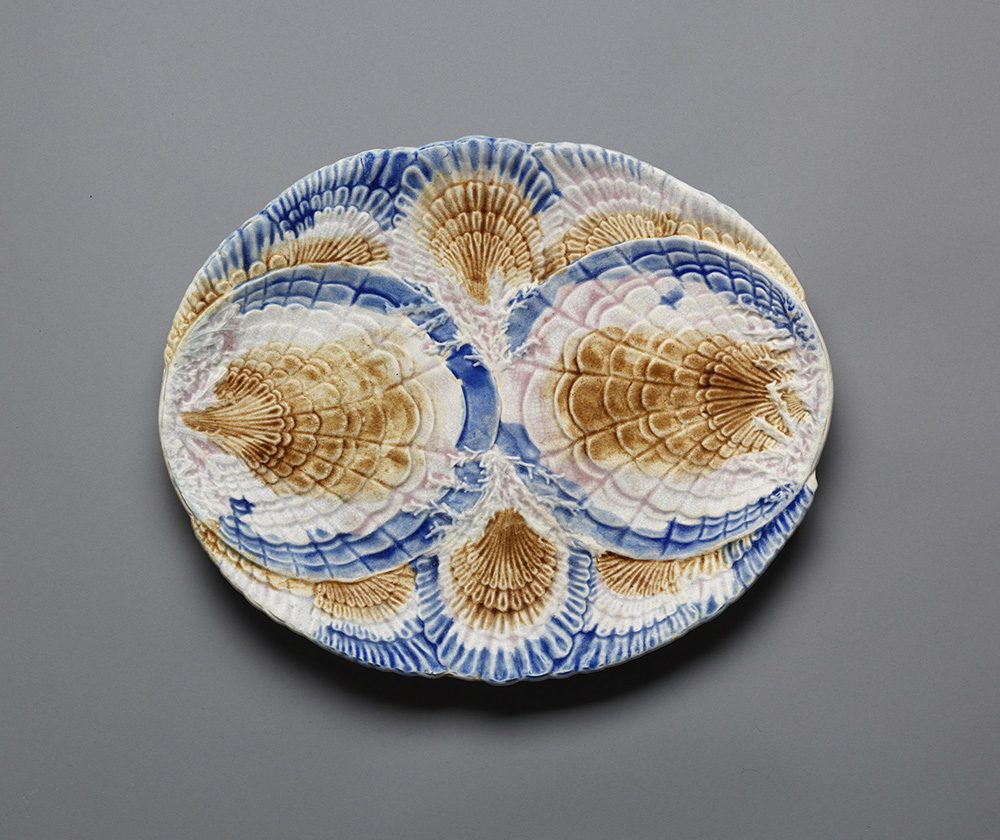 Majolica shell motif plate in blue, white, and brown.