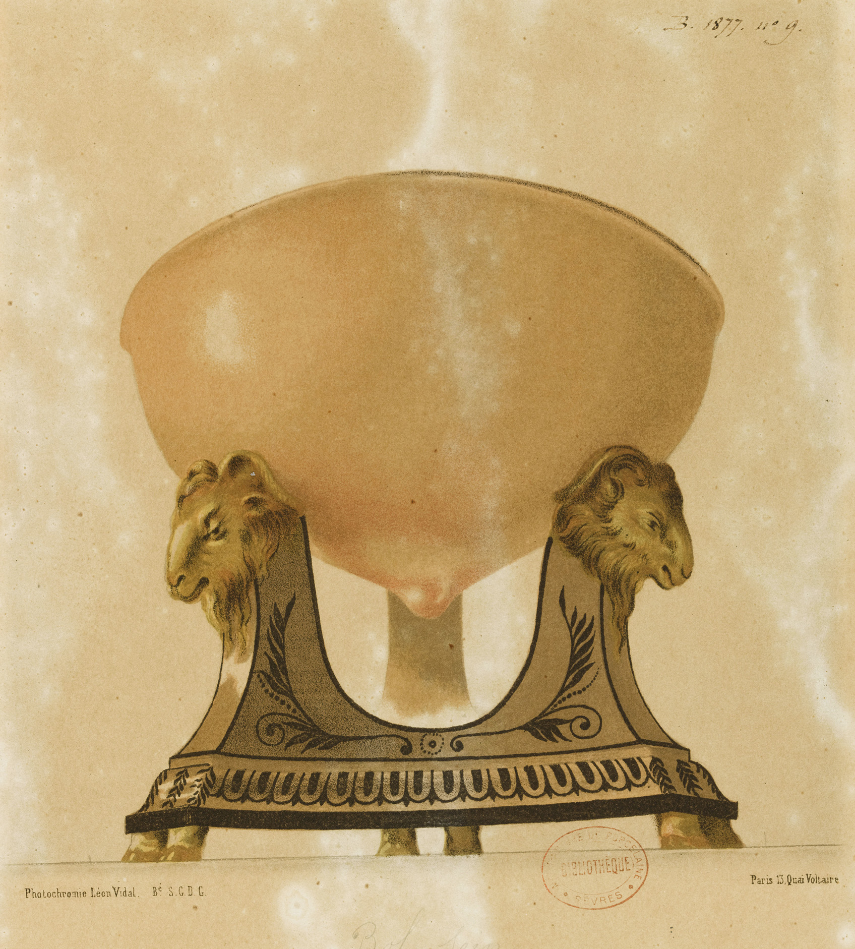 An ornate, antique bowl stands on a decorative, lion-themed pedestal base. The bowl is light in color and contrasts with the dark, intricately designed base featuring two lion heads on either side. The background is a textured neutral tone.