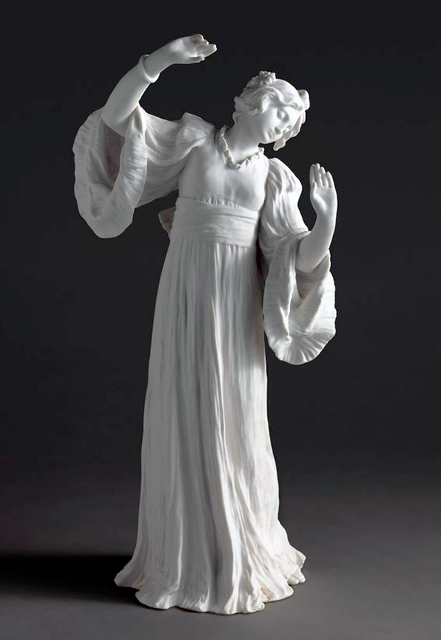 A white porcelain statue depicting a woman in flowing robes with raised arms, set against a dark background. The figure's expression is serene and graceful, capturing a sense of movement.