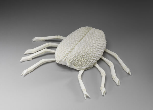 An intricate napkin sculpture depicting a crab with eight articulated legs and textured shell.