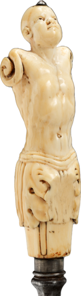 An intricate ivory knife hilt carved to resemble an human figure with head tilted back, a naked torso, scrolls in place of arms, and a leaf-shaped skirt.