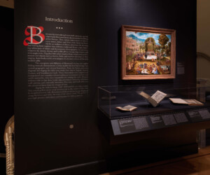 Introductory text panel for the "Staging the Table in Europe 1500-1800 Staging the Table in Europe 1500-1800" exhibition. A painting hangs above a case displaying several books to the right of the text.